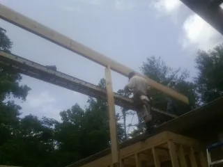 Carpenter setting a ridge beam over a new addition frame — Ice Dam Removal by Roofing Brothers in Vernonia