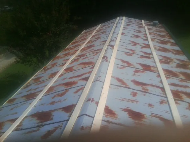 Rusted metal roof panels with new wood purlins before replacement — Storm Damage Roof Repair in Vernonia by Roofing Brothers