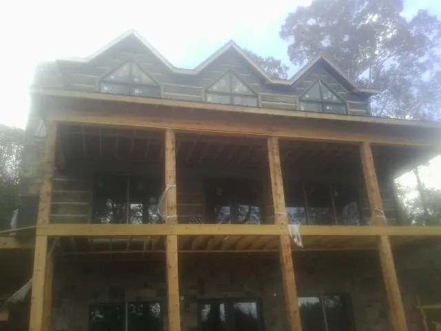 Dormers and porch framing on a large log home under construction — Roof Coating work by our crew in Vernonia