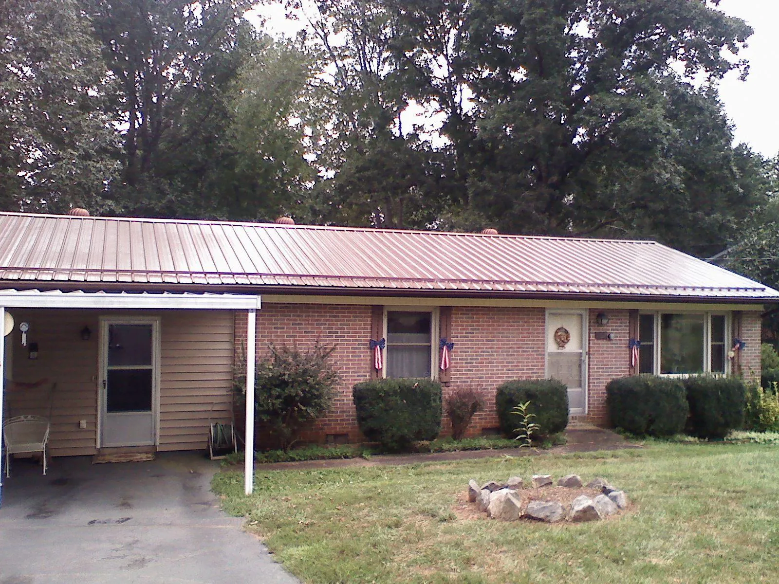 Bronze metal roof and carport on a brick ranch home — Roof Repair work by our crew in Vernonia